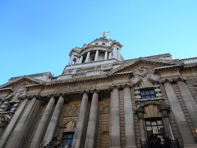 Man jailed after explosives guides found on phone Facade of a grand neoclassical building with tall columns and a domed tower against a blue sky.