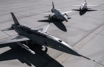Anduril’s FQ-44 drone fighter moves into production Three military fighter jets parked on a concrete airstrip with their shadows visible on the tarmac, seen from above.