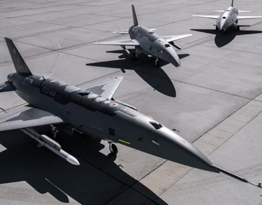 Three military fighter jets parked on a concrete airstrip with their shadows visible on the tarmac, seen from above.