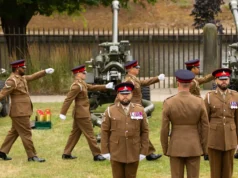 Catterick Garrison to get £12.3m sports facilities Group of soldiers in brown dress uniforms marching with large artillery guns in the background outdoors.