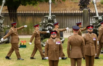 Catterick Garrison to get £12.3m sports facilities Group of soldiers in brown dress uniforms marching with large artillery guns in the background outdoors.
