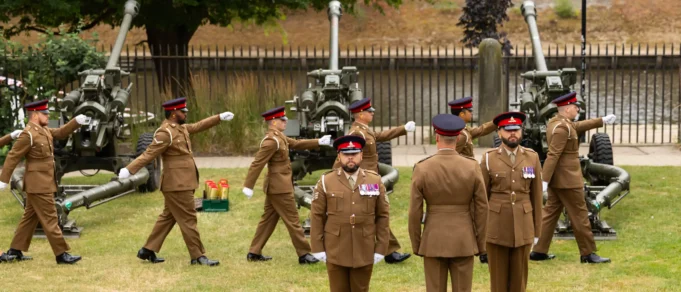Catterick Garrison to get £12.3m sports facilities Group of soldiers in brown dress uniforms marching with large artillery guns in the background outdoors.