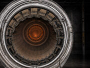 Close-up of a metallic turbine engine, concentric rings framing an orange-hot center, viewed head-on for an industrial feel