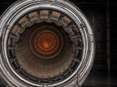 UK seeks disposable jet engines for low-cost missiles Close-up of a metallic turbine engine, concentric rings framing an orange-hot center, viewed head-on for an industrial feel