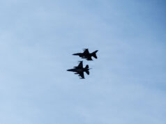 Romania shoots down second drone in two days Three silhouetted fighter jets fly in formation across a clear blue sky, with faint reflections below on the water surface.