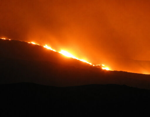 Military aid requested for raging Scottish wildfire Fire rips along a hillside at night, bright orange flames lighting the sky and smoke.