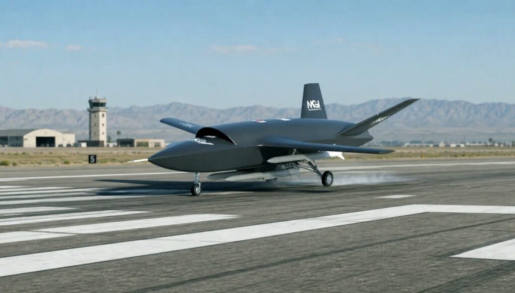 mgi2 Unmanned military drone taxiing on a runway with a control tower and desert mountains in the background.