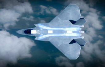 Engine for Britain’s next fighter jet moves toward testing Top-down view of a futuristic aircraft slicing through blue sky and clouds, glowing propulsion visible along its belly