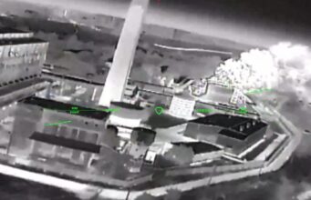 Ukrainian strikes moving to isolate Crimea, official says Night-vision aerial view of a rooftop building with smoke plume on the right and green HUD markers labeled 'FIRE POINT'.