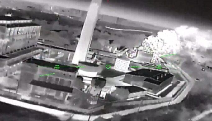 Ukrainian strikes moving to isolate Crimea, official says Night-vision aerial view of a rooftop building with smoke plume on the right and green HUD markers labeled 'FIRE POINT'.