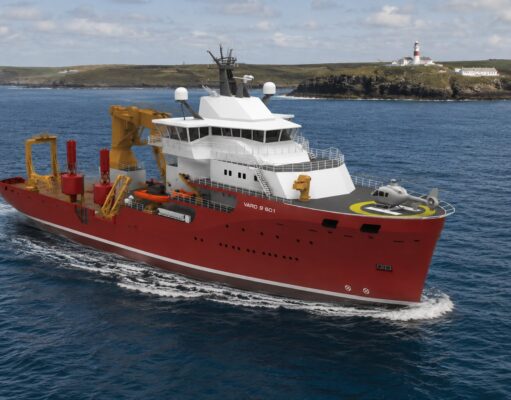 UK’s Trinity House awards huge ship deal to Norway’s VARD Red offshore support vessel with white superstructure and a yellow crane array, moving through open water; helicopter on the forward helipad and a lighthouse visible on a rocky coastline in the background, vessel marked VARD 9 601.
