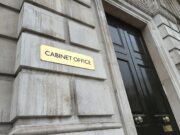 Social value weighting doubled in government contracts Gold plaque reading 'CABINET OFFICE' mounted on a weathered stone wall beside a tall black door with brass handles.