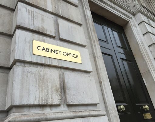 Social value weighting doubled in government contracts Gold plaque reading 'CABINET OFFICE' mounted on a weathered stone wall beside a tall black door with brass handles.