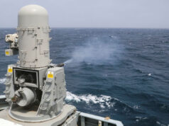 British warship opens fire in the Arabian Sea Naval gun turret on a gray battleship or naval vessel, facing the open ocean with waves in the background