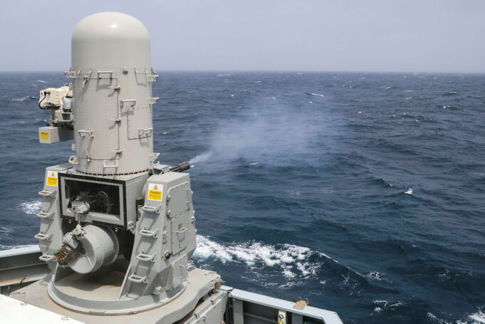 British warship opens fire in the Arabian Sea Naval gun turret on a gray battleship or naval vessel, facing the open ocean with waves in the background