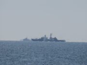 Russian warship opens fire near UK as British ship closes in Two warships sailing on the open sea near the horizon, silhouetted against a pale sky.