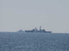 Russian warship opens fire near UK as British ship closes in Two warships sailing on the open sea near the horizon, silhouetted against a pale sky.