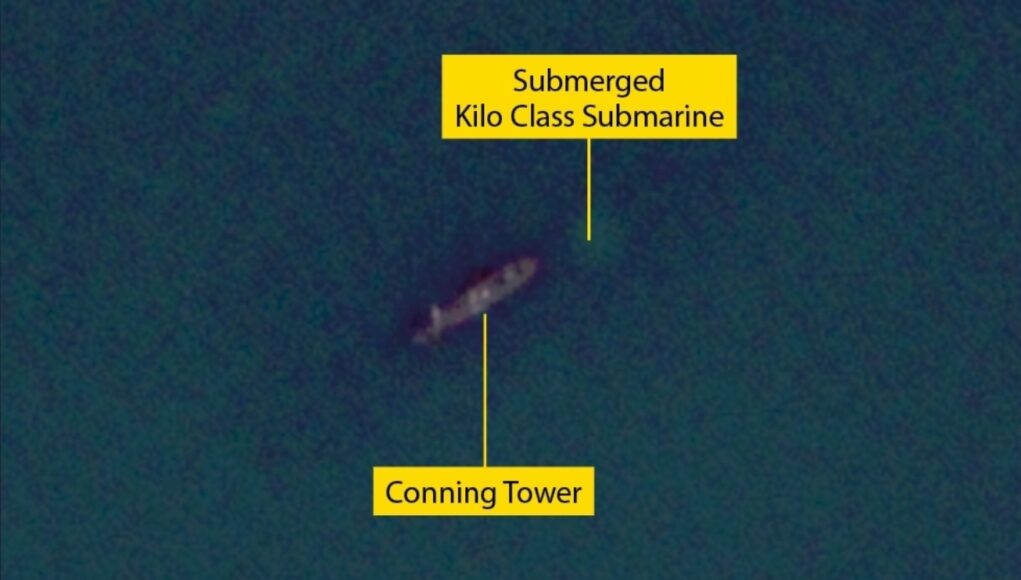 Submerged Kilo-class submarine with its conning tower visible underwater labeled in yellow boxes and lines to the parts.