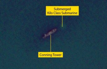 Submerged Kilo-class submarine with its conning tower visible underwater labeled in yellow boxes and lines to the parts.