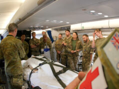 RAF medics train with Australians on Exercise Pitch Black Military medics gathered around a patient on a stretcher inside a military aircraft, preparing a medical evacuation.