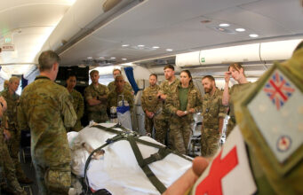 RAF medics train with Australians on Exercise Pitch Black Military medics gathered around a patient on a stretcher inside a military aircraft, preparing a medical evacuation.
