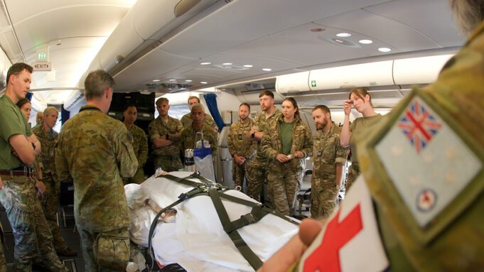RAF medics train with Australians on Exercise Pitch Black Military medics gathered around a patient on a stretcher inside a military aircraft, preparing a medical evacuation.