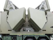 Two large olive-green panels folded into a symmetric V shape on a military vehicle, suggesting a radar or missile launcher mounted on a truck chassis.