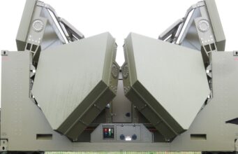 Two large olive-green panels folded into a symmetric V shape on a military vehicle, suggesting a radar or missile launcher mounted on a truck chassis.