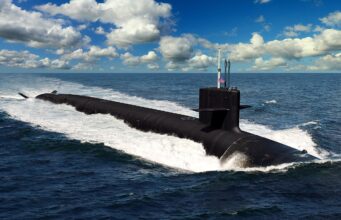 A dark submarine gliding at the ocean surface, creating a white wake with a blue sky and clouds above, a small American flag on the conning tower.