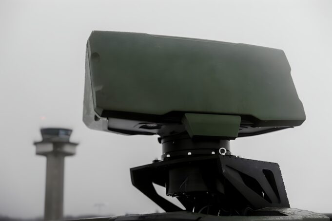 Radar network kept working after GPS timing was cut Close-up of a green military weapon mount on a vehicle with a blurred distant tower in the background