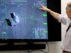British firm Inzpire to train Ukrainian pilots in air tactics Person in a light shirt points at a large screen displaying a flight navigation/avionics interface with green markers and data.