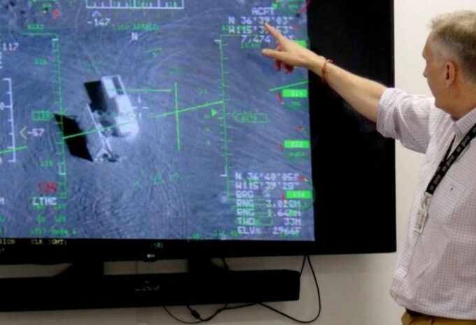 British firm Inzpire to train Ukrainian pilots in air tactics Person in a light shirt points at a large screen displaying a flight navigation/avionics interface with green markers and data.