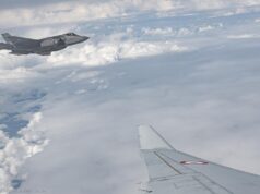 NATO rehearses hunting and killing targets on eastern border Military jet flying above clouds, seen from a passenger plane window; French Air Force markings visible on the fuselage.