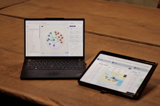 The British firm sizing military powertrains in hours Laptop shows a circular data dashboard while a tablet displays a map dashboard on a wooden table.