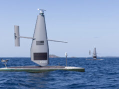 Saildrone USV credited in $81m cocaine interdiction Autonomous sailing drone on a flat catamaran, a tall gray sail with the number 2040, sailing on open blue sea.