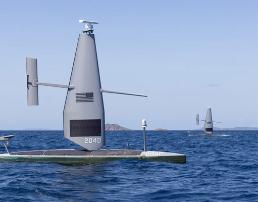 Autonomous sailing drone on a flat catamaran, a tall gray sail with the number 2040, sailing on open blue sea.