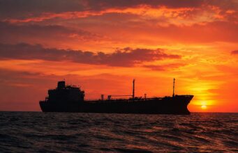 Indian-flagged ship sunk in Red Sea attack off Yemen Silhouetted cargo ship on a choppy sea at sunset with an orange sky behind it