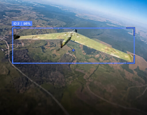 Camouflaged military aircraft in flight over farmland, with a blue HUD box showing ID 2 and 96%.